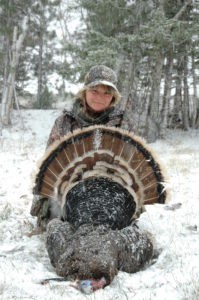 Hunter takes picture with gobbler in the snow
