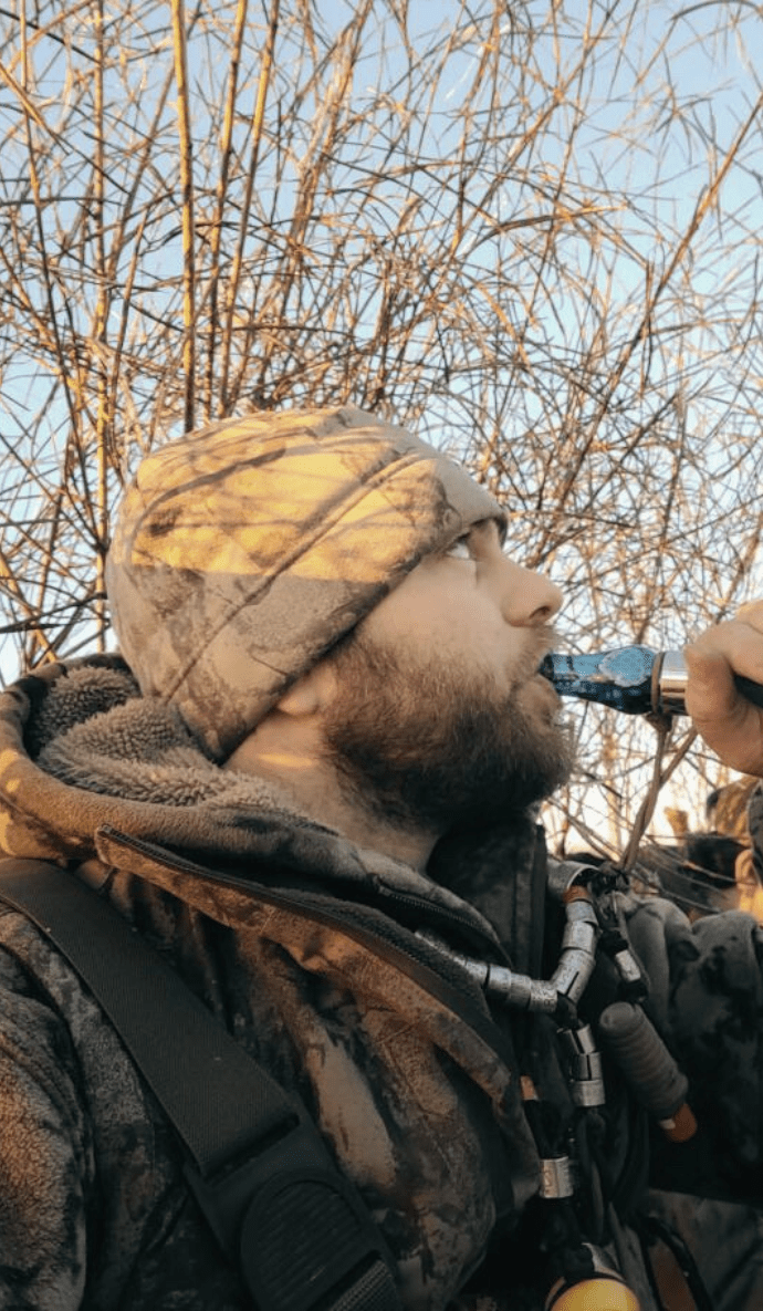 hunter in the field using the ranger double reed duck call in blue wing mesh