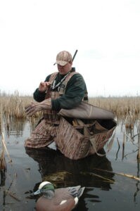Duck hunter holding decoy bag over shoulder: pre-season decoy prep