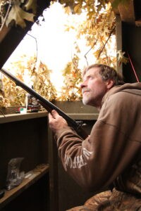 Duck hunter in the duck blind holding 12-gauge muzzleloader