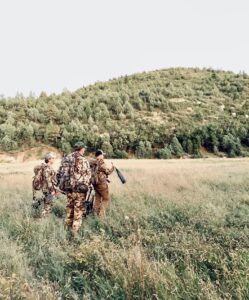 pre-season elk scouting with Chance Robbins, three elk hunters in the field with one hunter holding a Slayer elk bugle