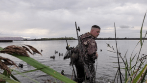 Q&A With Travis Tweet: Pre-Season Shotgun Maintenance, header image shows Travis Tweet in the field wading through the water