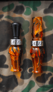Slayer's acrylic honker goose call pictured next to Field & Stream's BEST double reed duck call, the Ranger - in citrine water mesh color.