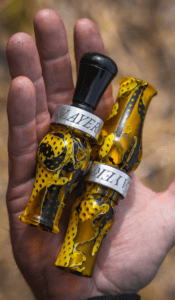 Slayer's acrylic honker goose call pictured next to Field & Stream's BEST double reed duck call, the Ranger - in yellow jacket mesh color.